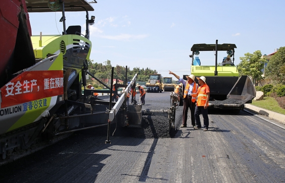 攤鋪機(jī)、壓路機(jī)等設(shè)備緊張有序運(yùn)行，高達(dá)170℃的瀝青混合料炙烤著公路人